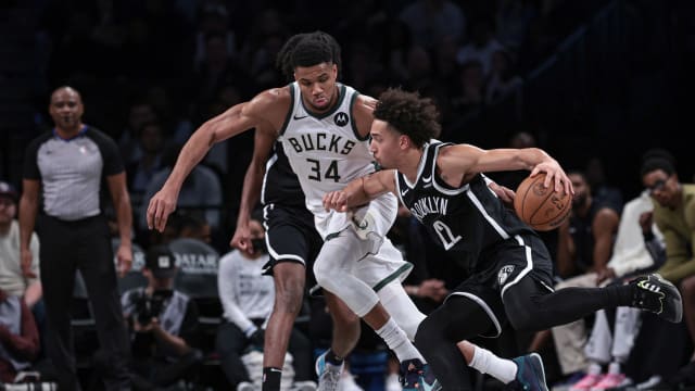 Brooklyn Nets forward Jalen Wilson (22) dribbles against Milwaukee Bucks forward Giannis Antetokounmpo (34) 